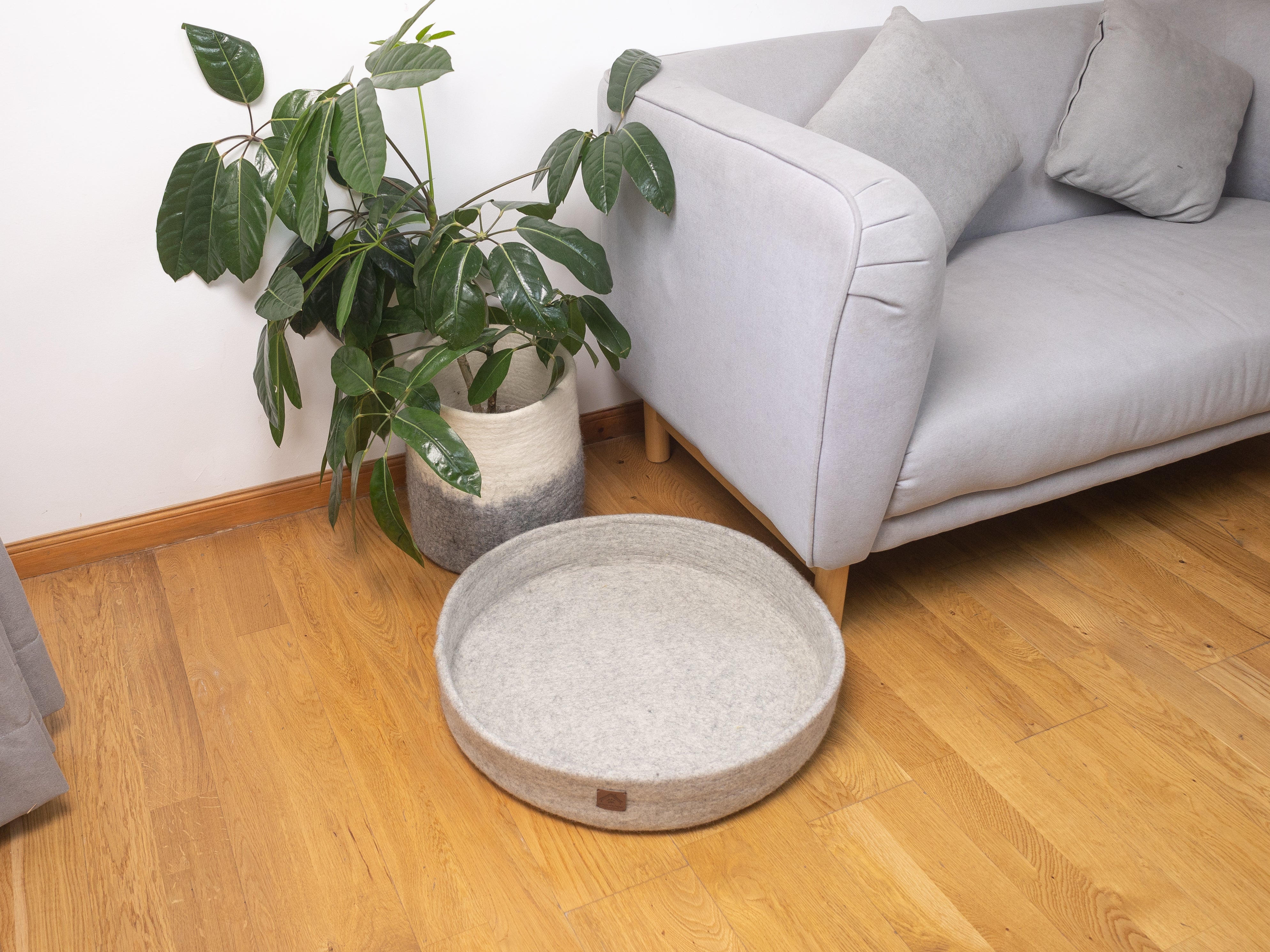 round grey dog bed on floor 