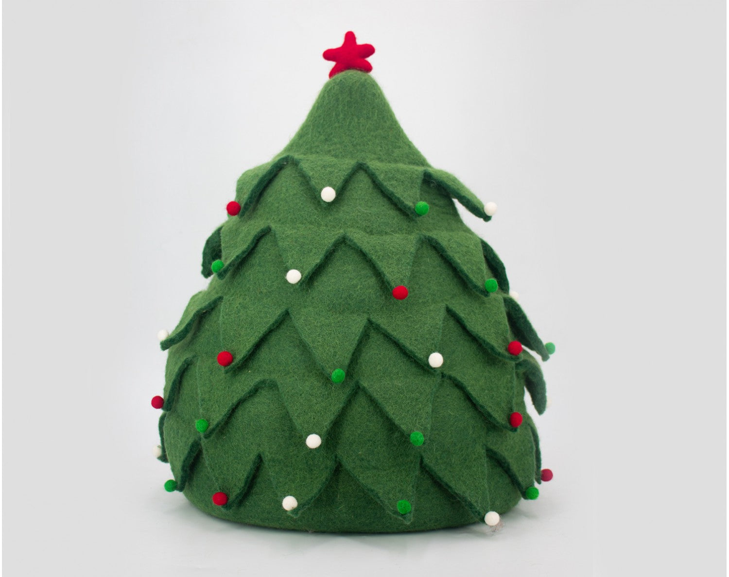 Green felt Christmas tree ornament with red and white decorations on a light gray background